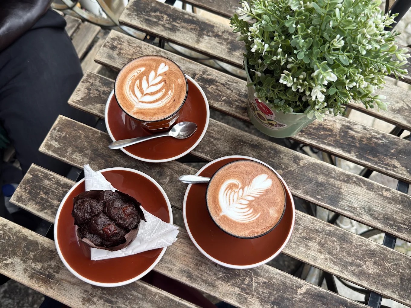 Two cappuccinos with latte art and a chocolate muffin at My Coffee Porto